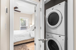 A laundry room with two stacked front-loading washing machines. - Designer-Private Heated Pool-Golf Cart (Miramar Beach)