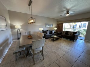 A living room with a dining table, sofas, and a ceiling fan. - 2405 Spacious 3/3 Resort Condo Near Disney (Orlando)