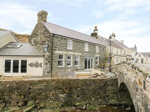 A stone building with a cafe named 'Caffi Hen BLAS Cafe' and a stone bridge in the foreground. - Hen Blas (Pwllheli)