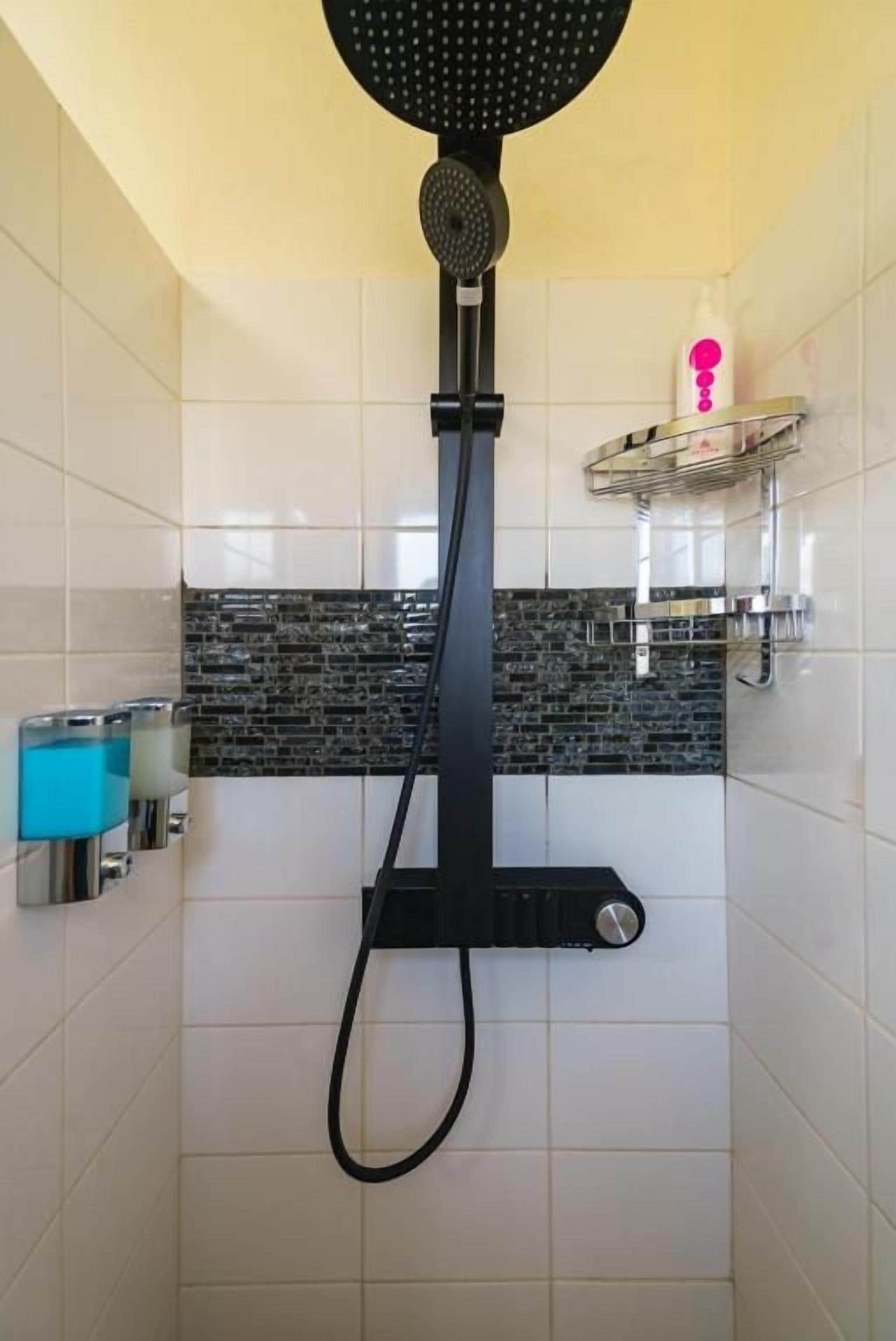 A shower with a black hose and a round head.