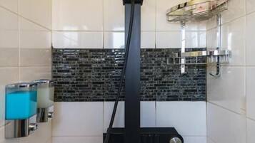 A shower with a black hose and a round head.