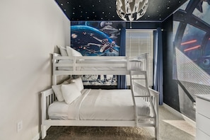 A bunk bed in a room with a starry space-themed wall mural and a window with blinds. - 2779 Oxymoron Way (Kissimmee)
