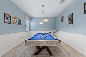 A pool table in a room with blue walls, white wainscoting, and ceiling lights. - 1427 Wexford Way (Davenport)