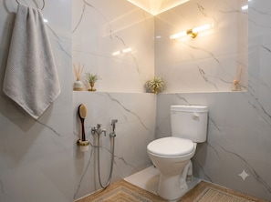 A bathroom with a toilet, shower, and towel rack. - Hotel Shree Kripa (Ujjain)