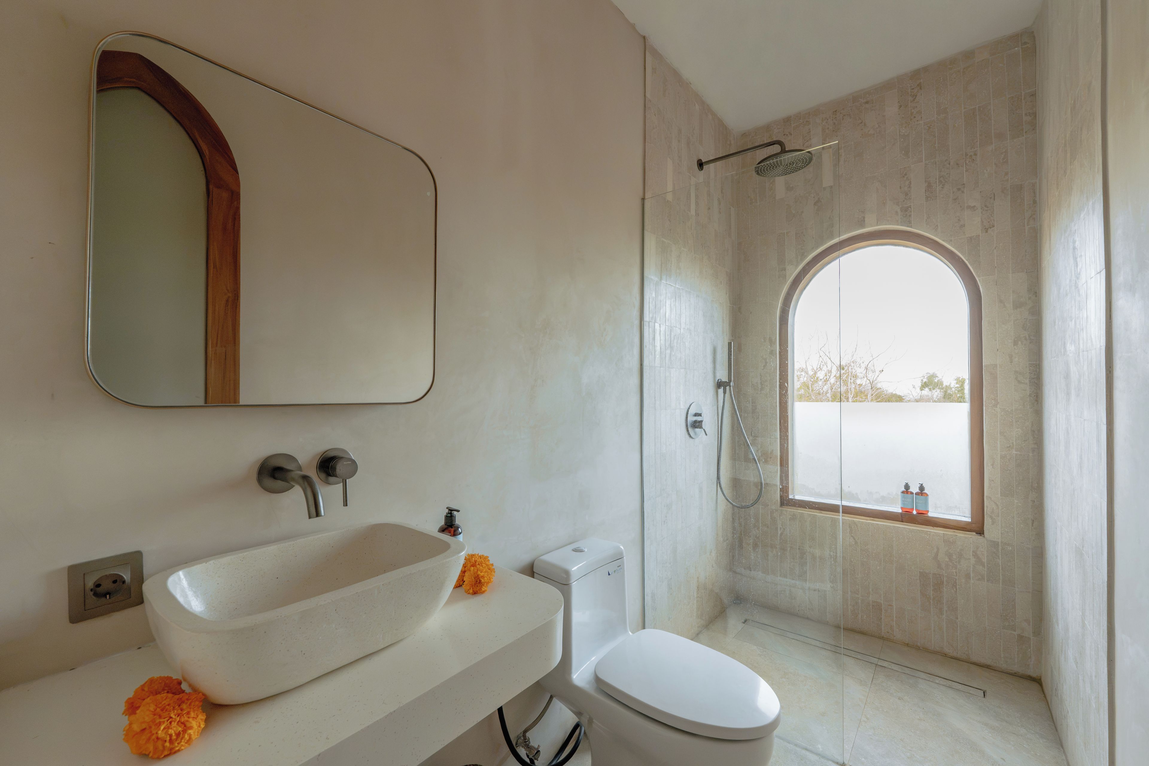 A bathroom with a white sink, a toilet, and a shower with a glass door.