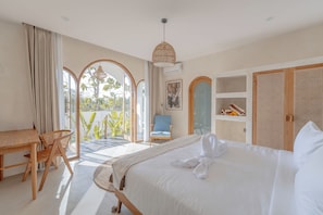 Une chambre d’hôtel avec un lit, un bureau, une chaise et une vue sur l’extérieur.