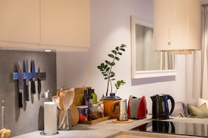 A modern kitchen with a coffee machine, a plant, and various kitchen utensils. - Modern Apartment in Tromsø Center (Tromsø)