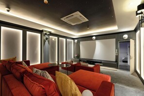 Un salon moderne avec un canapé rouge, une table basse et un téléviseur à écran plat.