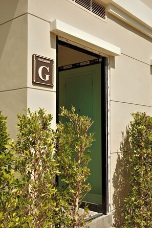 A building entrance with a sign labeled 'BUILDING G' and a glass door. - Bang Tao - King and Twin Comfort (Choeng Thale)