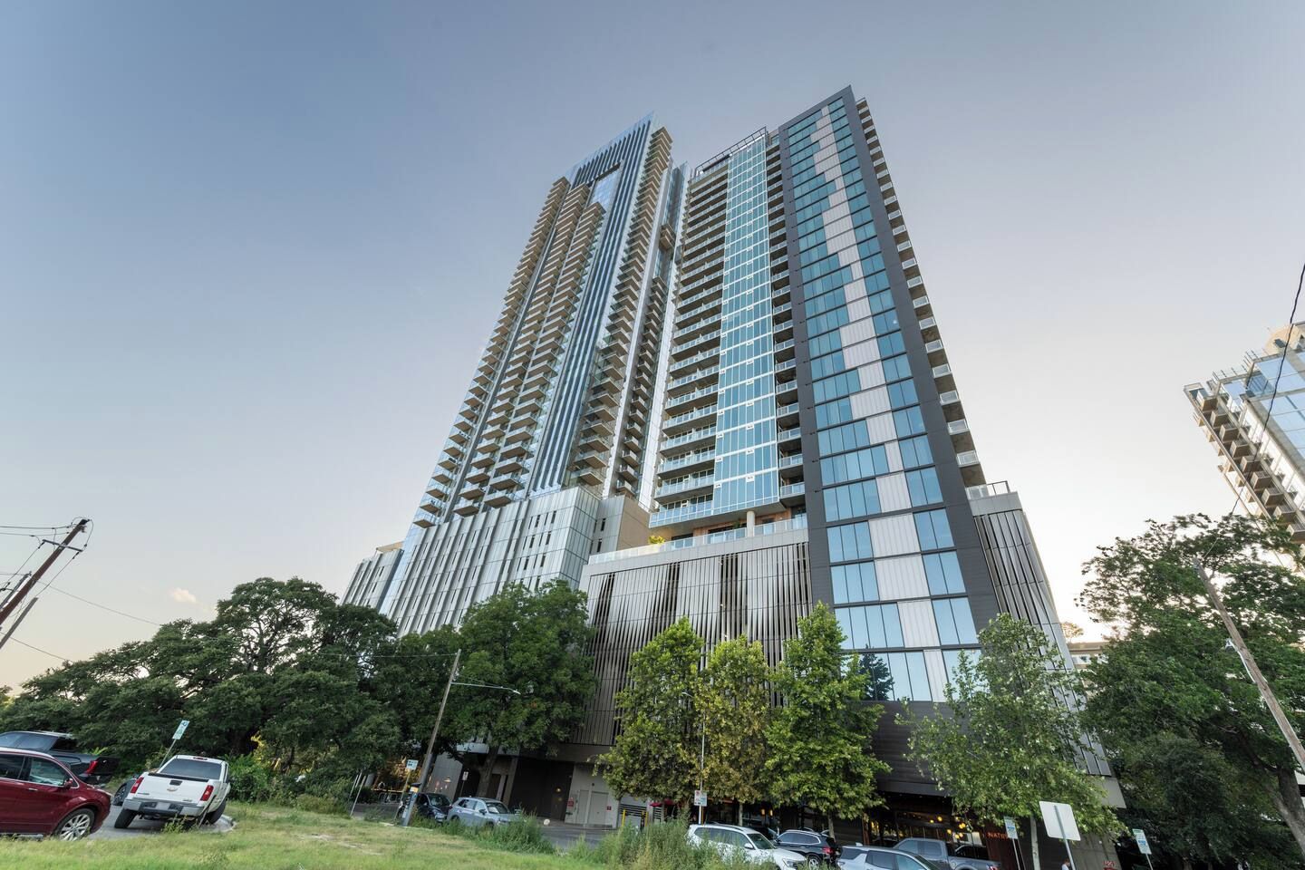 A high-rise building with multiple balconies and a glass facade.
