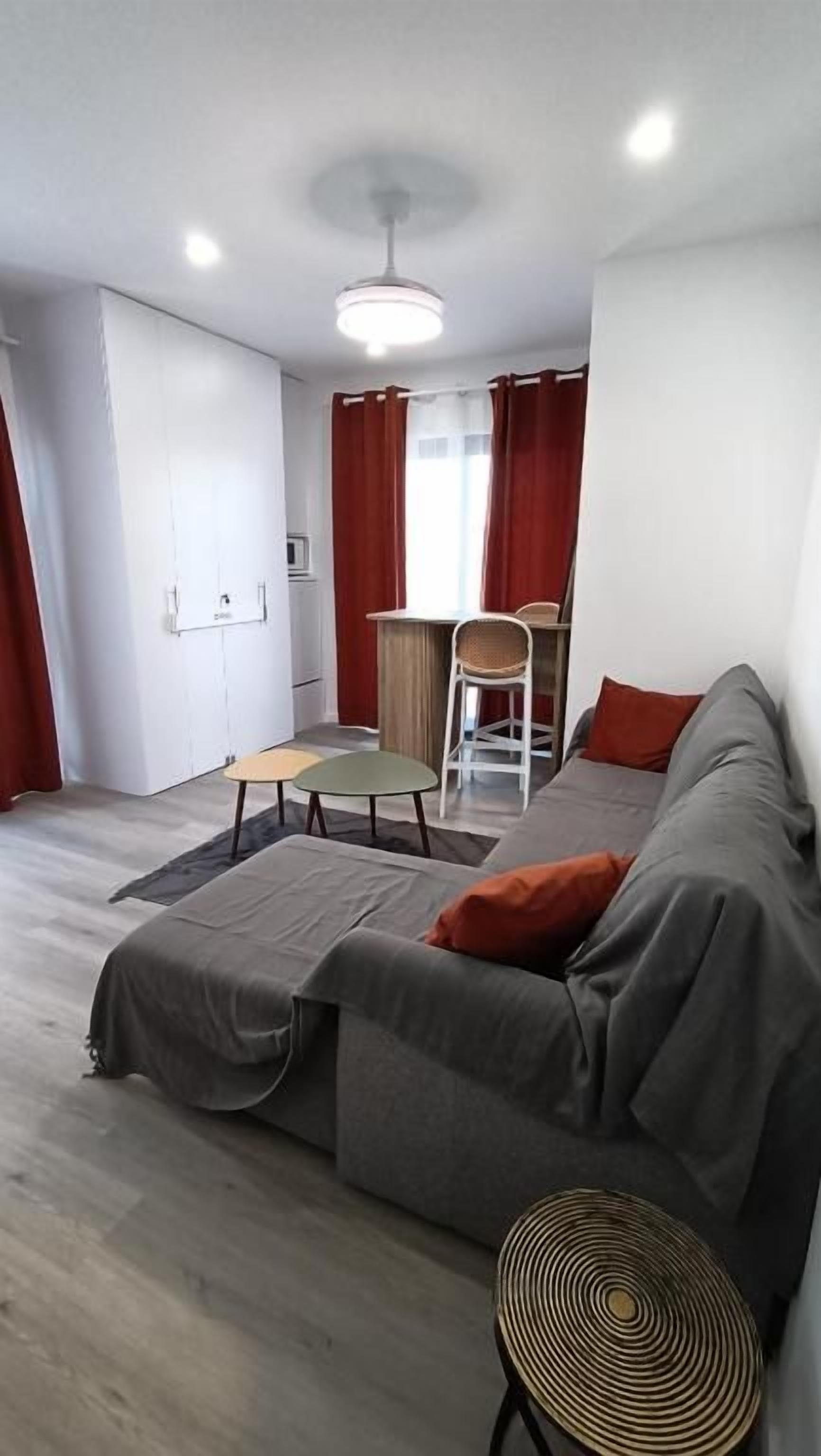 Un salon moderne avec un canapé, une petite table et un fauteuil.