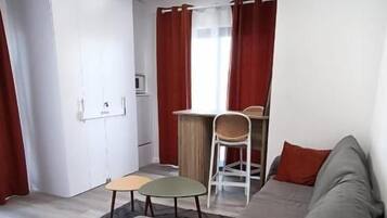 Un salon moderne avec un canapé, une petite table et un fauteuil.