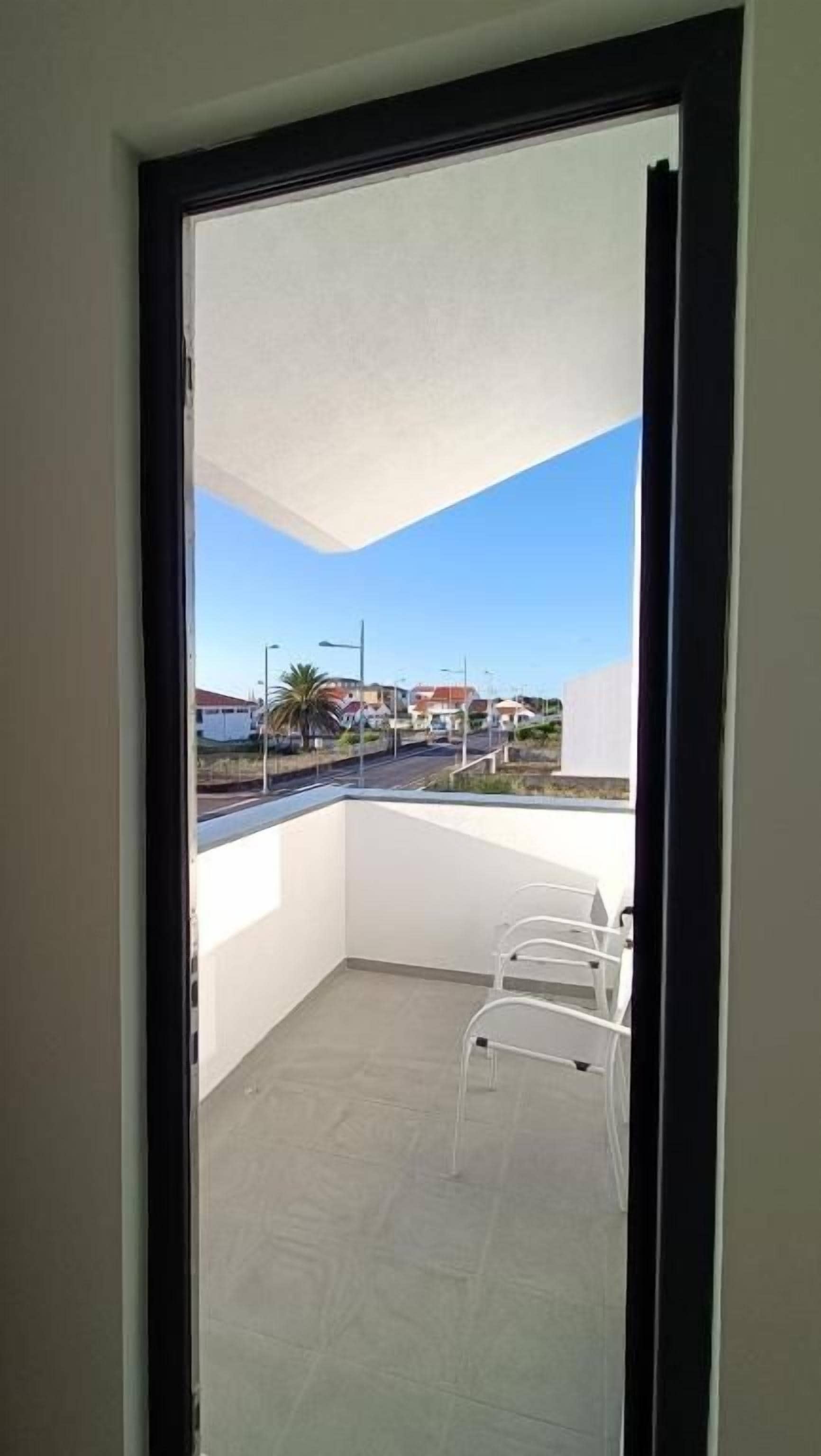 A balcony with a clear view of the street and buildings.