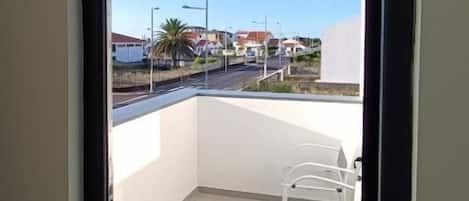 A balcony with a clear view of the street and buildings.