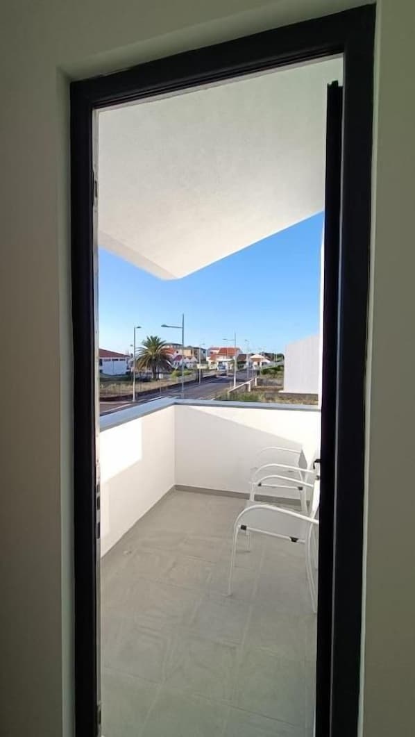 A balcony with a clear view of the street and buildings.