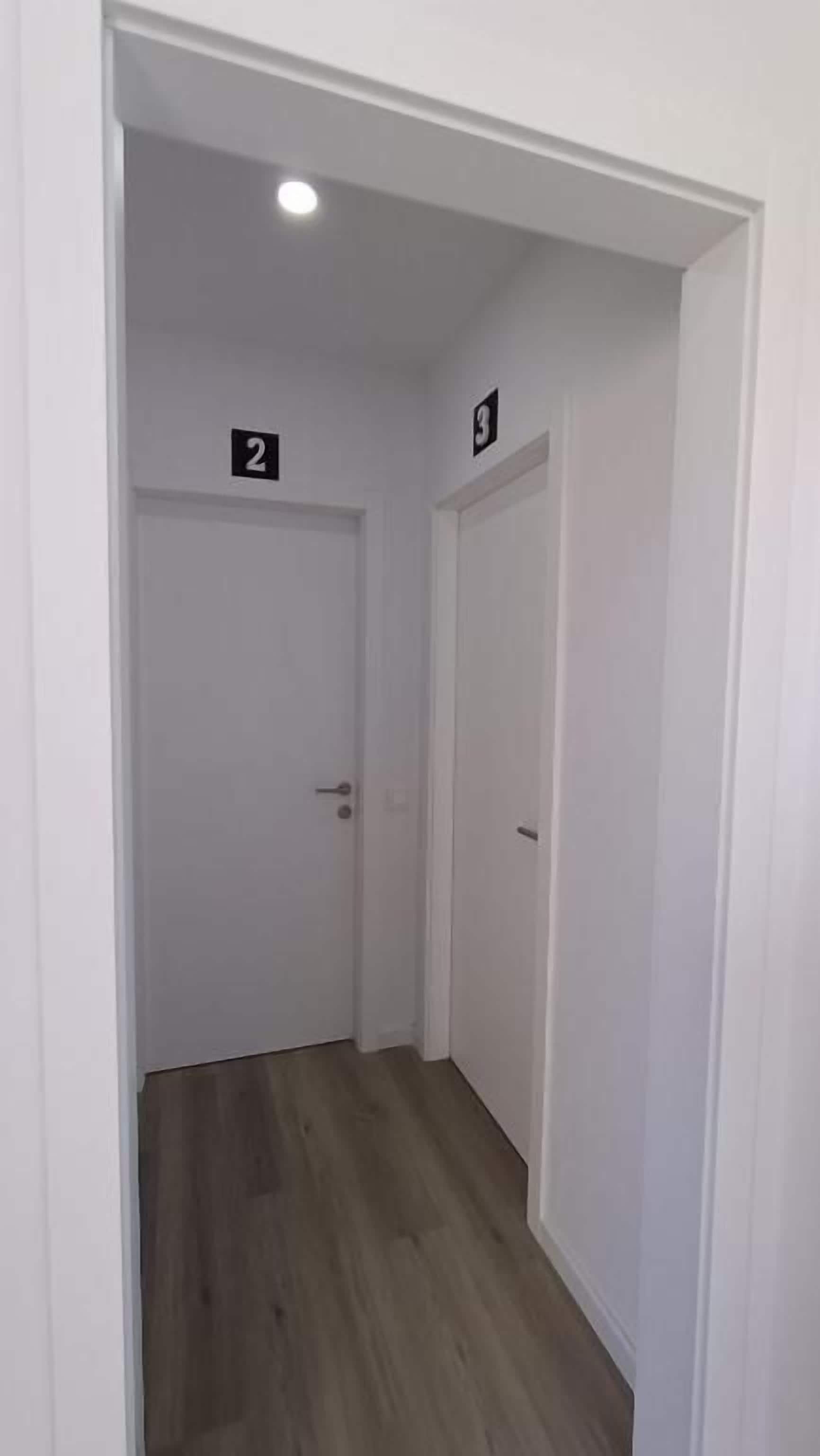 A narrow hallway with two doors, each marked with a number.