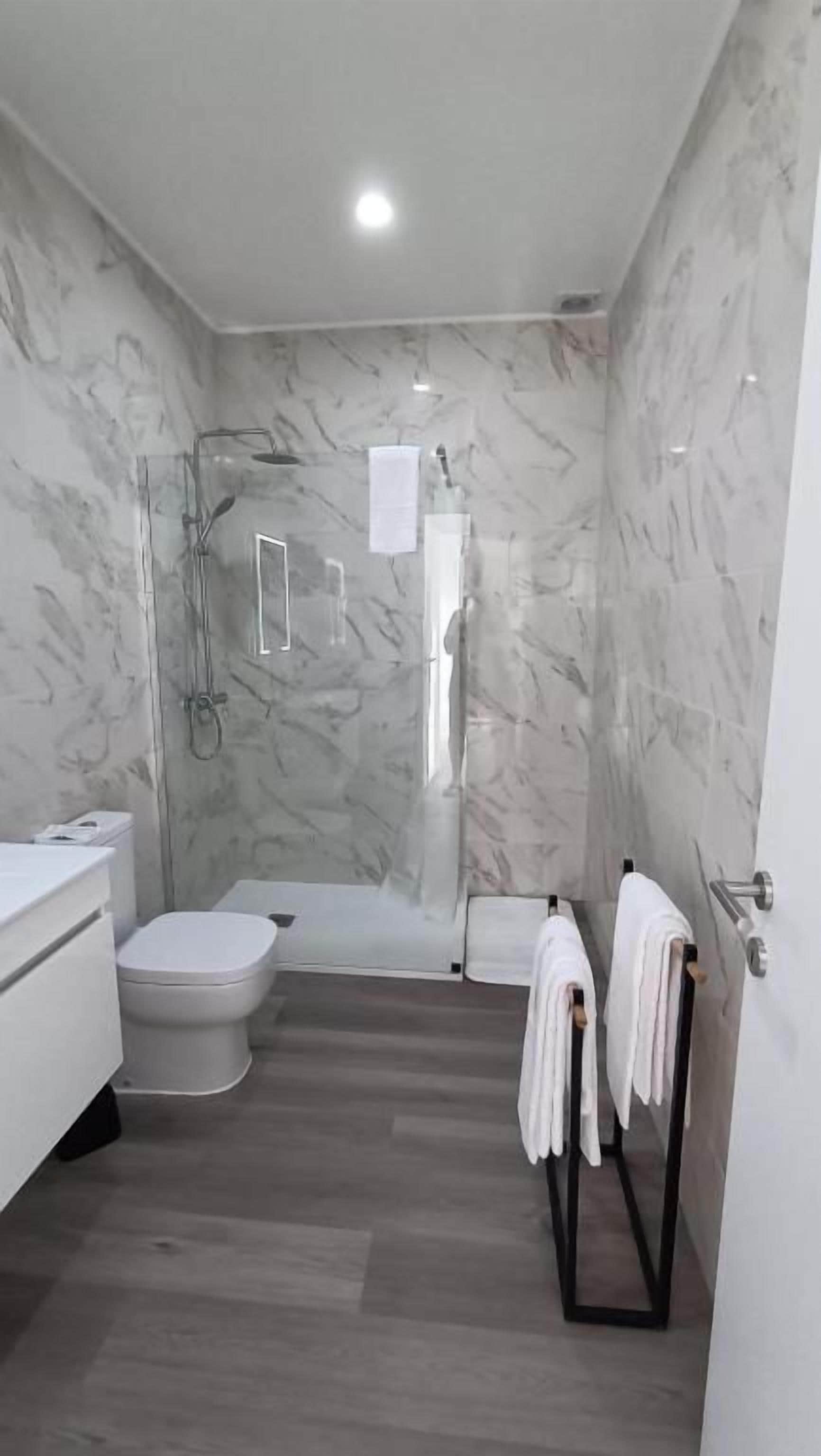 A bathroom with a shower, toilet, and sink.