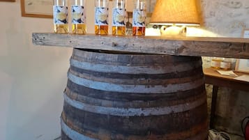 A wooden barrel used as a bar counter with several bottles of liquor on top.