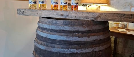 A wooden barrel used as a bar counter with several bottles of liquor on top.