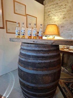 Una barrica de madera utilizada como barra, con varias botellas de licores encima.
