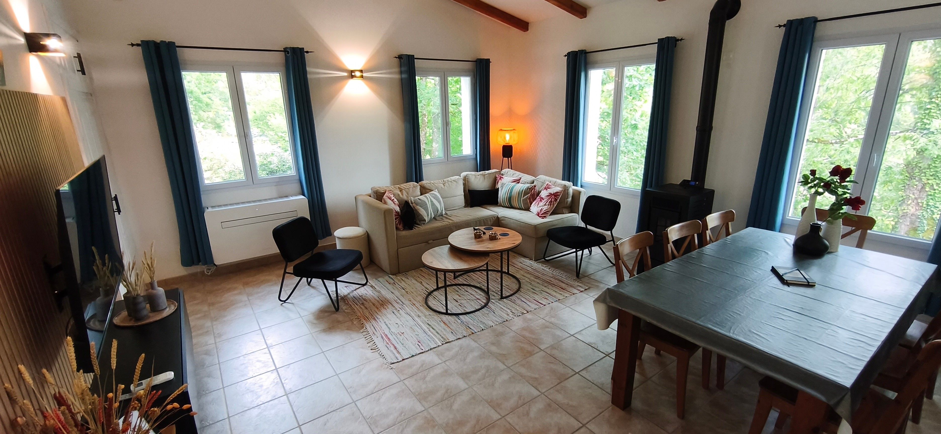 Ein Wohnzimmer mit einer Couch, Sesseln, einem Esstisch und einem Kamin.