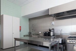 A modern kitchen with stainless steel appliances, a coffee machine, and a gas stove.