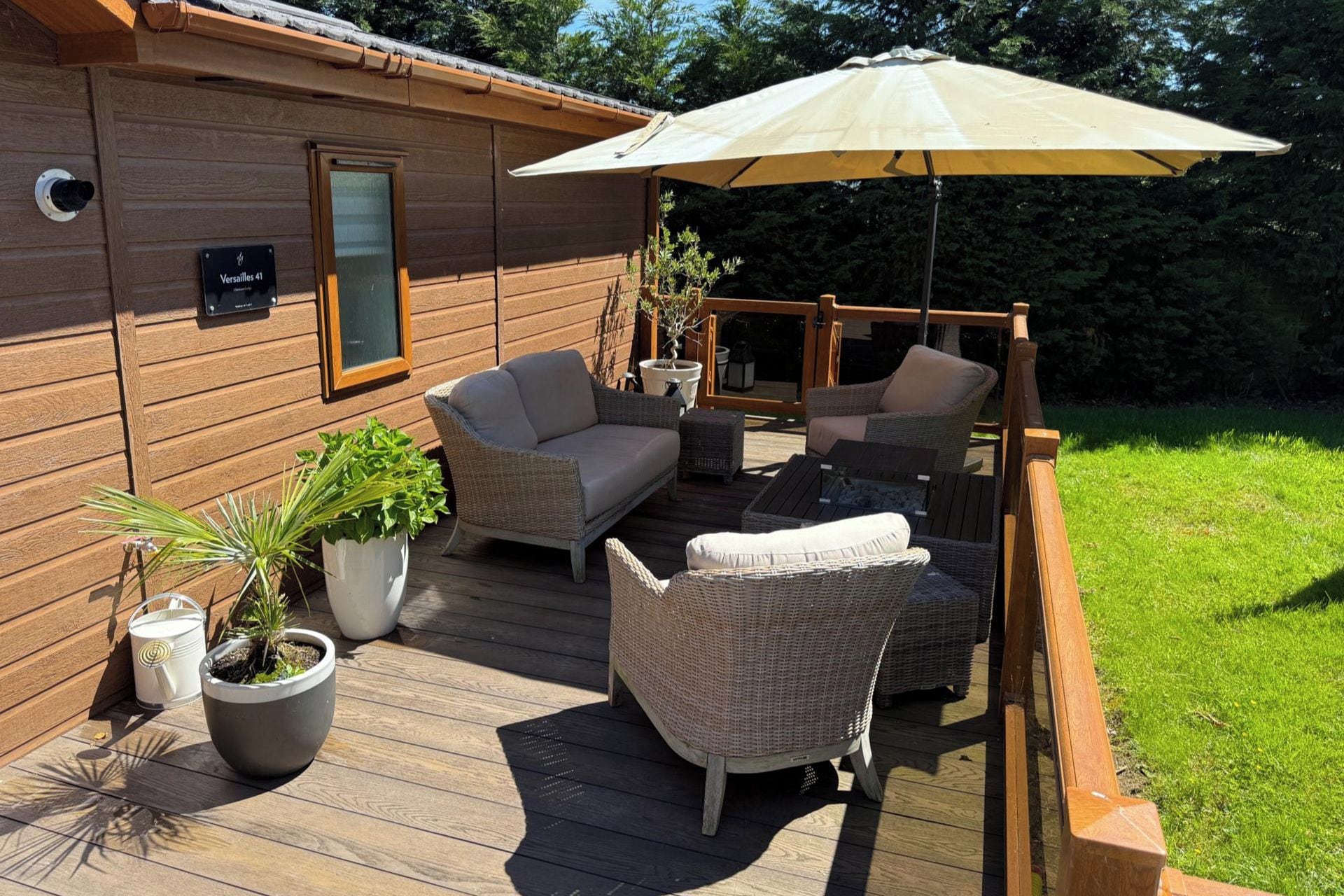 A wooden deck with wicker furniture, a potted plant, and a sign reading 'Versailles 41'.