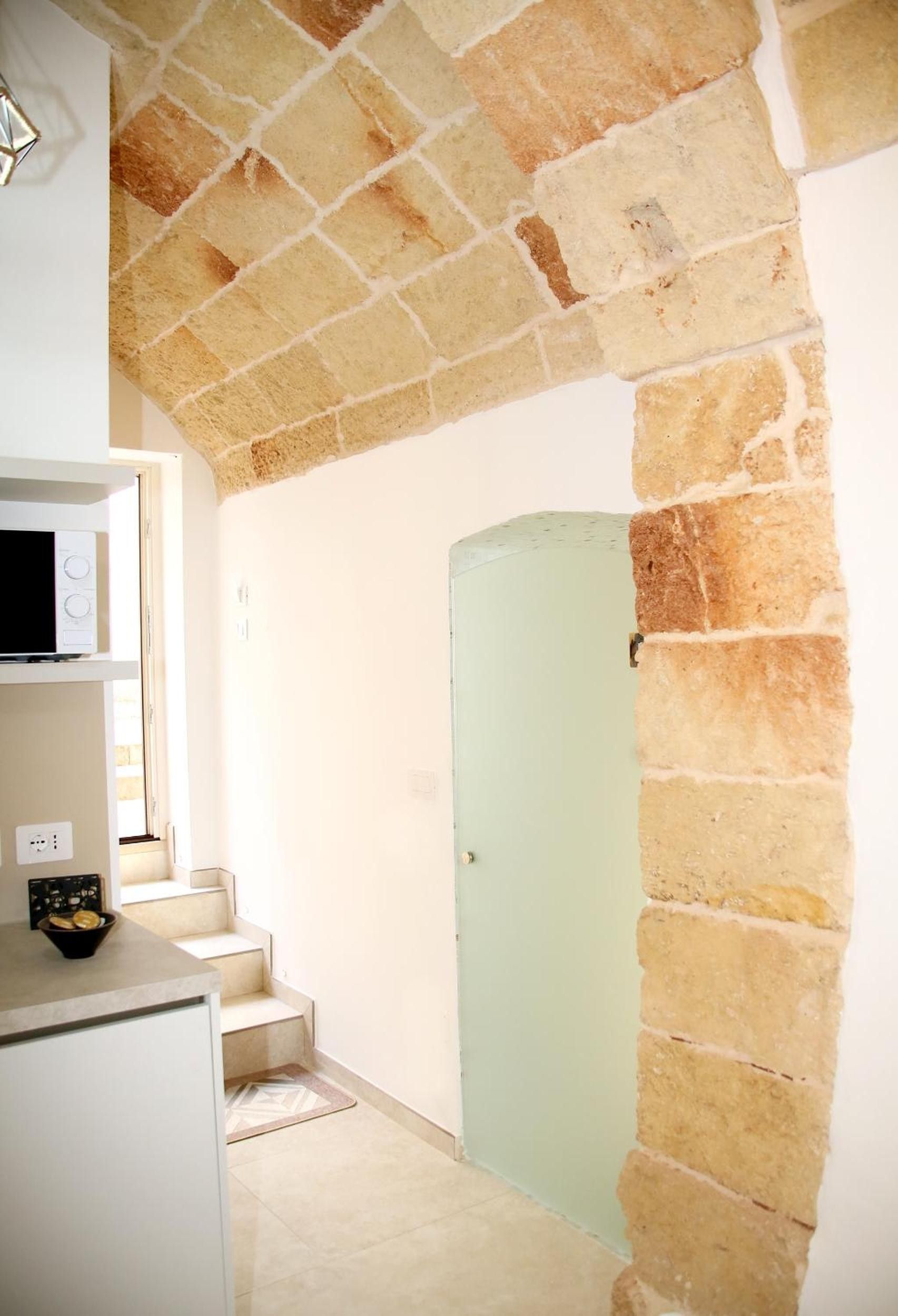 Eine Küche mit einer Mikrowelle, einer Schüssel mit Brot und einer Treppe, die zu einer Tür führt.