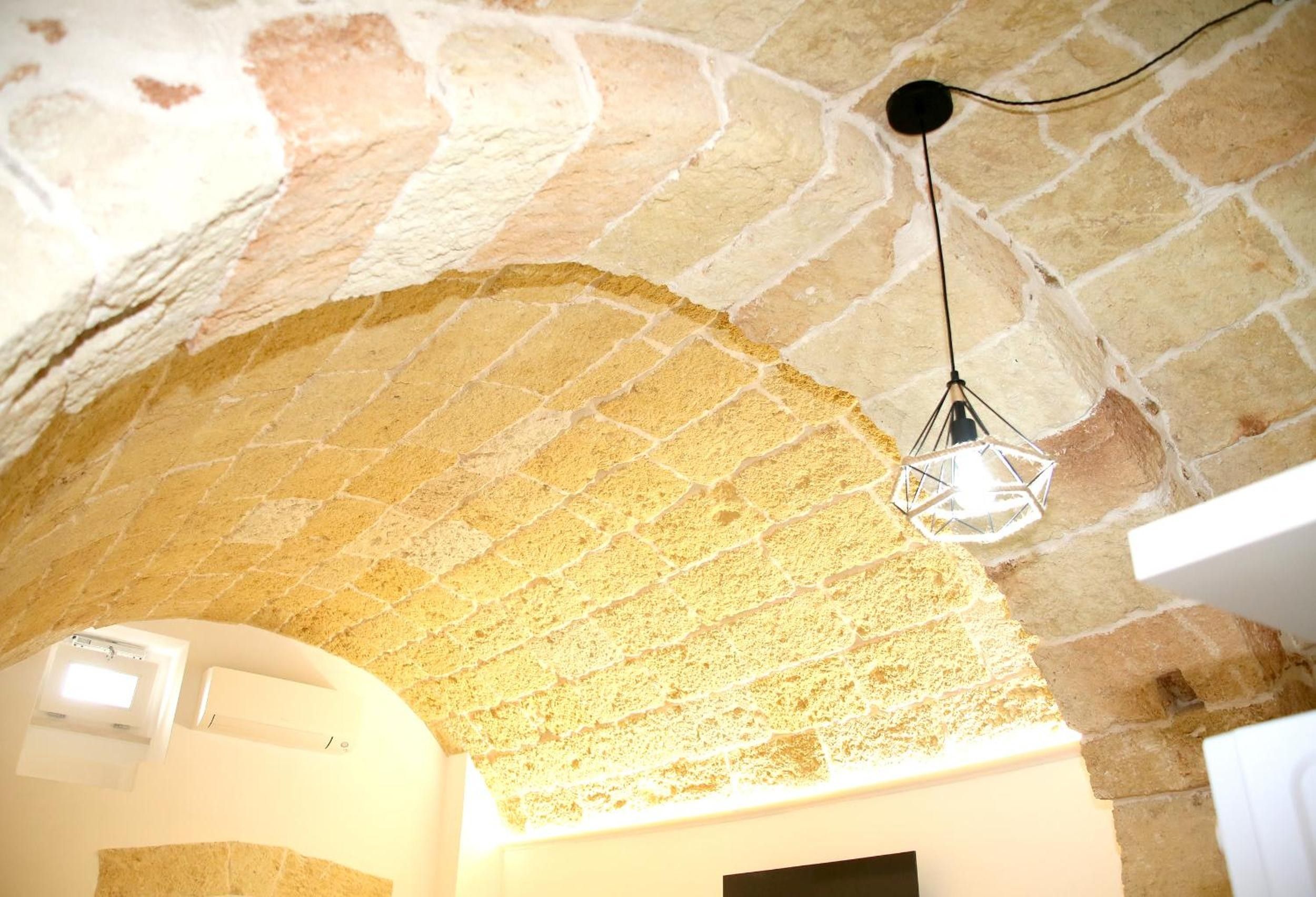 A stone ceiling with a hanging light fixture.