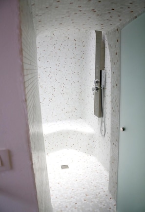 Een badkamer met een douche, toilet en wastafel.