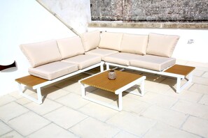A sectional sofa with a wooden coffee table and two side tables.