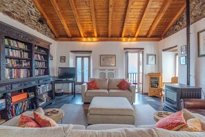 A cozy living room with a fireplace, a television, a sofa, and a bookshelf. - Casa Rustica (San Siro)