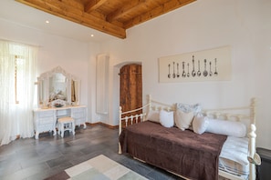 A bedroom with a bed, a dresser, a mirror, and a wall-mounted artwork. - Casa Rustica (San Siro)