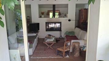 A living room with a sofa, a coffee table, a television, and a cabinet.