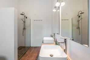 Een moderne badkamer met een rechthoekig wastafel, een spiegel en een douchehoek.