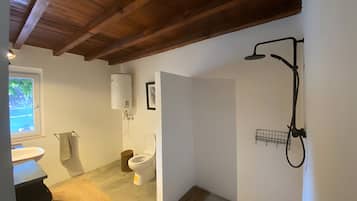 A bathroom with a shower, toilet, and sink.