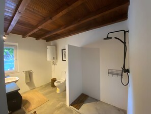 Un baño con ducha, inodoro y lavabo.