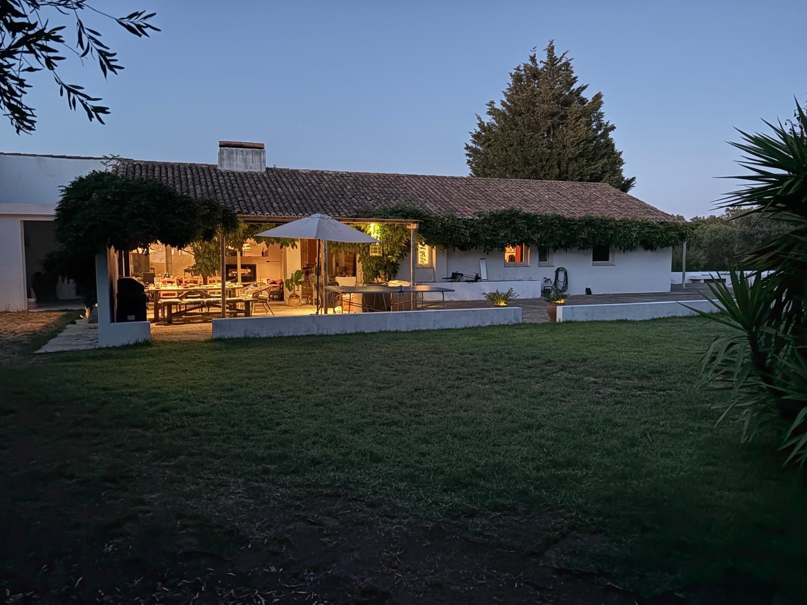 A residential property with a patio area, outdoor seating, and a covered section.