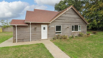 A single-story house with a red-tiled roof, a front door, and a small front yard.