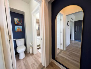 Een badkamer met toilet, wastafel en spiegel.