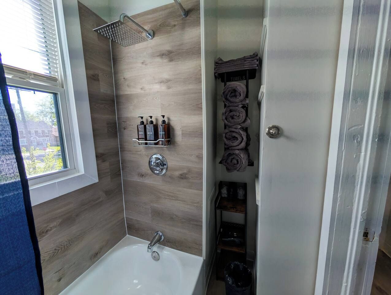 A bathroom with a shower, a bathtub, and a towel rack.