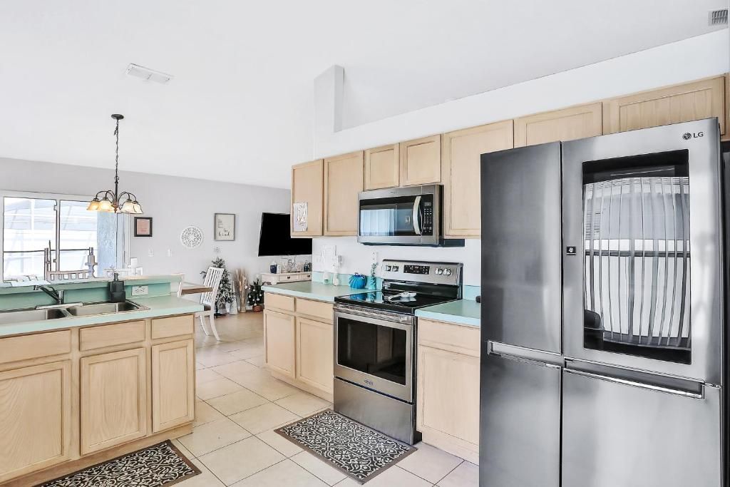 A modern kitchen with stainless steel appliances, wooden cabinets, and a large island.