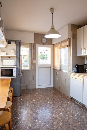 A kitchen with a refrigerator, microwave, and a dining table with chairs. - 5BR Penthouse · Huge Sea-View Terrace · Sleeps 12 (Fuengirola)