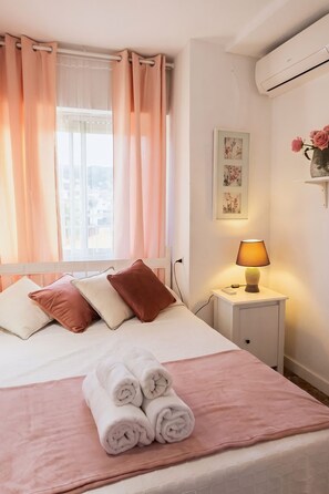 A neatly made bed with pillows, a bedside lamp, and a rolled towel on a white bedspread. - 5BR Penthouse · Huge Sea-View Terrace · Sleeps 12 (Fuengirola)