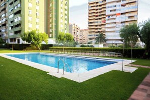A rectangular swimming pool with a metal ladder, surrounded by well-maintained grass and a fence. - 5BR Penthouse · Huge Sea-View Terrace · Sleeps 12 (Fuengirola)