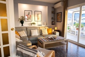 A modern living room with a sofa, coffee table, and artwork on the wall. - 5BR Penthouse · Huge Sea-View Terrace · Sleeps 12 (Fuengirola)
