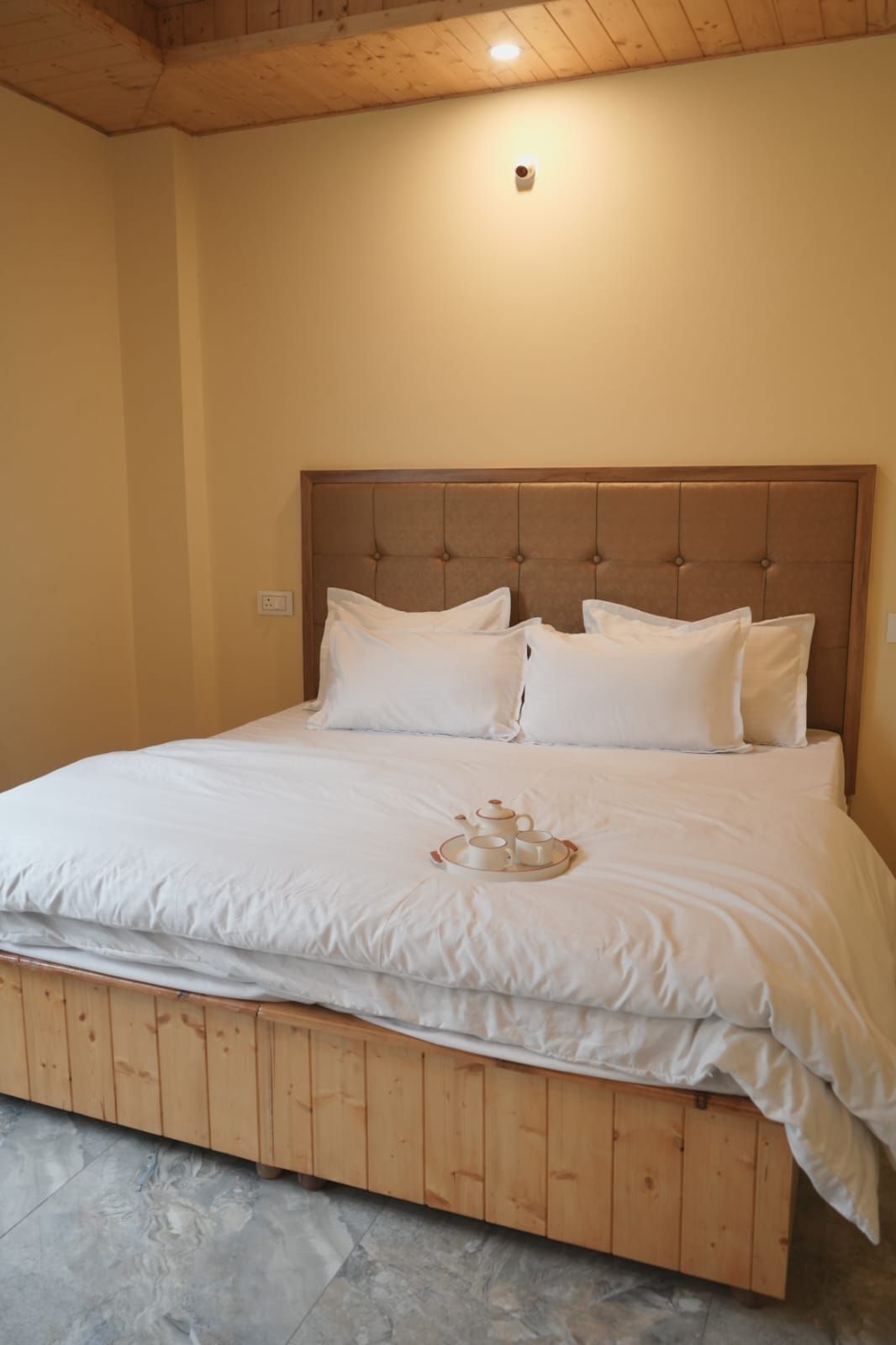 A bed with a wooden headboard and white bedding.