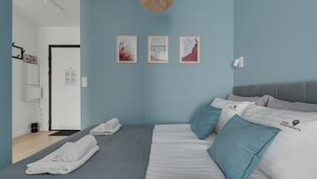 A modern bedroom with a bed, pillows, and artwork on the wall.