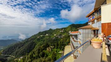 A hotel with a balcony overlooking a mountainous landscape.