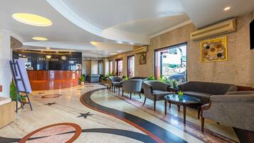 A reception area with a reception desk, seating area with sofas and armchairs, and a decorative floor design.
